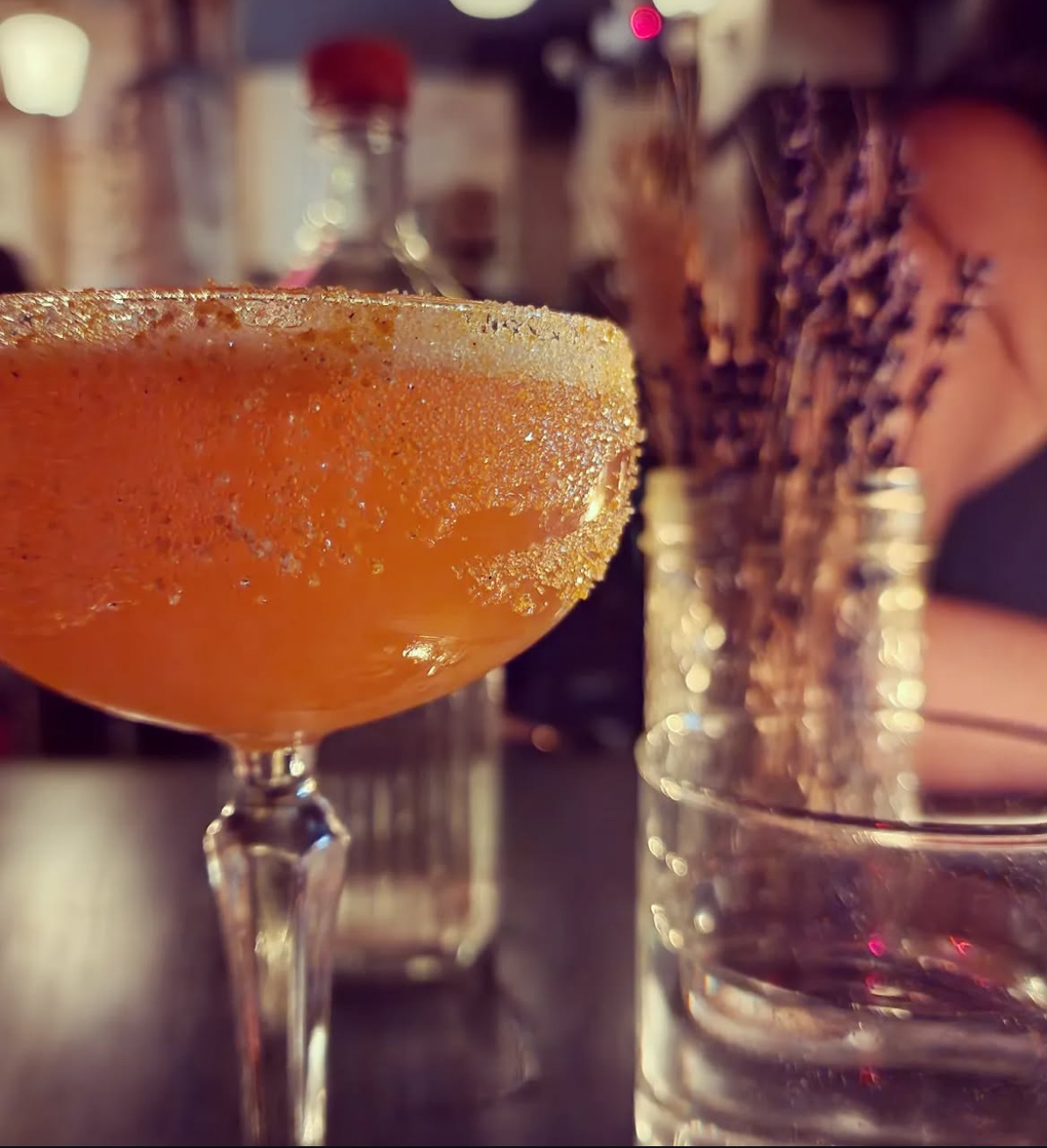 A chili-salt rimmed cocktail glowing on the bar at Headless Widow